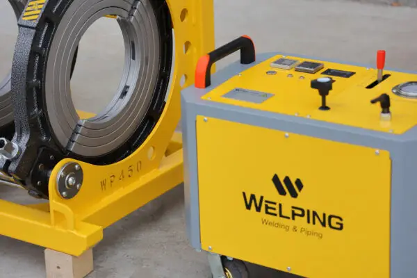 Modernt plastsvetsverktyg och svetsutrustning för plast med märkningen "WELPING Welding & Piping" på en gul maskinenhet och svart-gul plastsvetsarmatur monterad på gult stativ.
